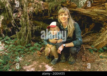 Mutter und Sohn hocken auf einer Wanderung im Hoh Rainforest im Olympic National Park. Stockfoto