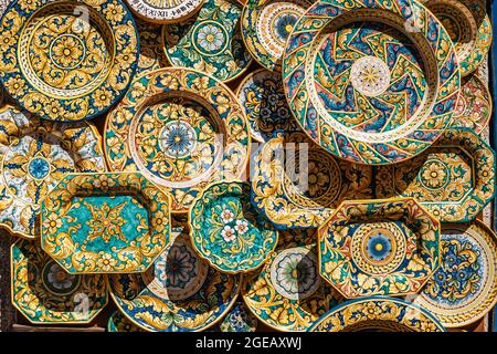 Erice, Sizilien. Farbenfrohe, handgedekorierte Keramik. Traditionelles touristisches Suvenir. Straßenhändler mit handgefertigten Handarbeiten.Teller mit ornamentaler Dekoration. Stockfoto