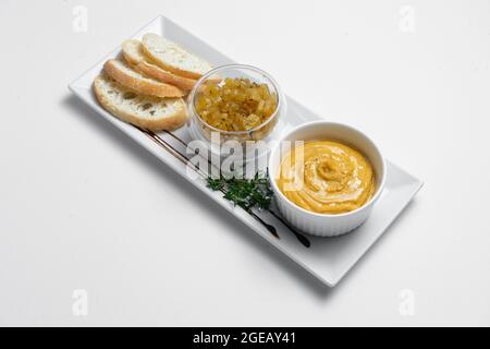 Nahaufnahme von Gänseleber-Pastete mit Apfelchutneys und Brot auf weißem Hintergrund Stockfoto