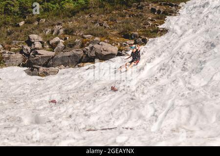 Kleiner Junge, der im Sommer im Schnee bei Heather Meadows im Mt. Baker-Snoqualmie National Forest. Stockfoto