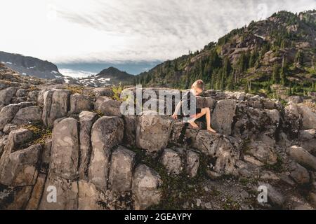 Kleiner Junge klettert auf Lavasteinsäulen bei Heather Meadows im Mt. Baker-Snoqualmie National Forest. Stockfoto