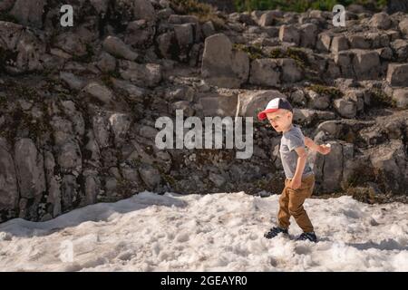 Kleiner Junge wirft Schneebälle im Sommer auf Heather Meadows im Mt. Baker-Snoqualmie National Forest. Stockfoto