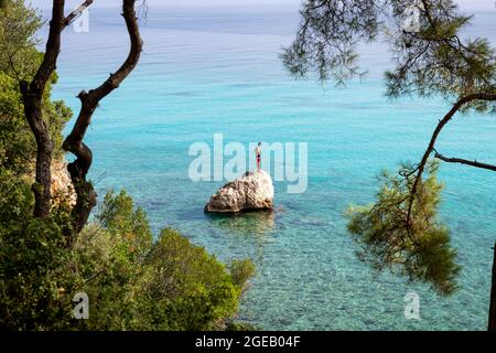 Insel Lefkada. Griechenland- 08.05.2021: Ein Tourist, der auf einem Felsen steht und bereit ist, in das wunderschöne türkisfarbene Meer einzutauchen. Stockfoto