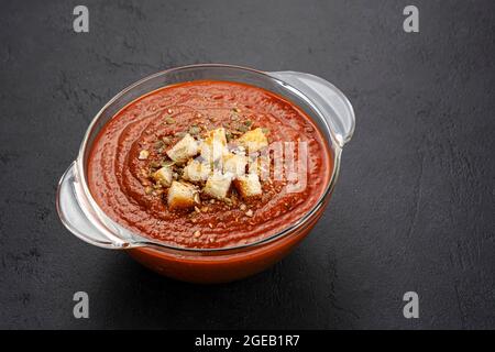 Schüssel Tomatensuppe auf schwarzem Hintergrund Stockfoto