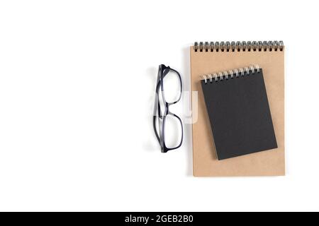 Zwei Notizblöcke und eine Brille liegen auf einer weißen Oberfläche Stockfoto