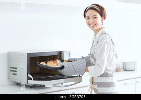 Japanische Frau, die zu Hause kocht Stockfoto