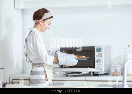 Japanische Frau, die zu Hause kocht Stockfoto