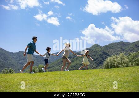 Glückliche junge chinesische Familie, die Spaß im Freien hat Stockfoto