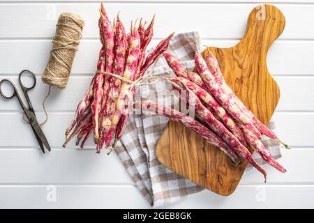 Cranberry-Bohnen. Bohnen-Pads auf Schneidebrett. Draufsicht. Stockfoto