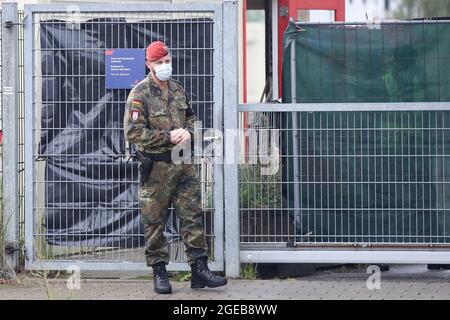 Hamburg, Deutschland. August 2021. Vor einer Aufnahmeeinrichtung in Hamburg-Rahlstedt steht ein Polizeibeamter. Die ersten lokalen afghanischen Truppen, die aus Kabul geflogen sind, kamen am frühen Abend in einer Aufnahmeeinrichtung in Hamburg an. Kredit: Bodo Marks/dpa/Alamy Live Nachrichten Stockfoto