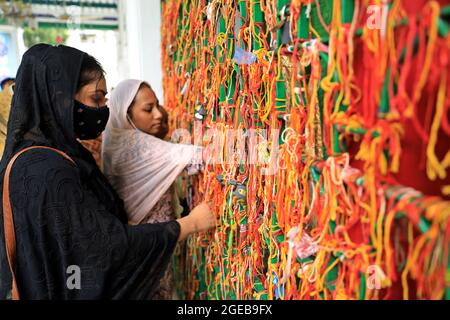 Nicht exklusiv: DHAKA, BANGLADESCH - 18. AUGUST: Muslimische Frauen binden die Tajia als Gebetszeichen, während sie an einer religiösen Zeremonie teilnehmen, um der zu gedenken Stockfoto