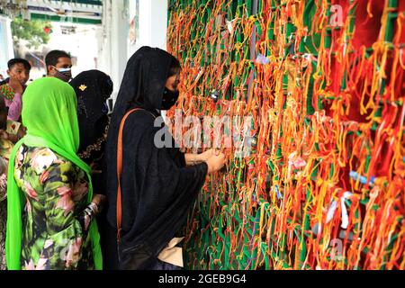 Nicht exklusiv: DHAKA, BANGLADESCH - 18. AUGUST: Muslimische Frauen binden die Tajia als Gebetszeichen, während sie an einer religiösen Zeremonie teilnehmen, um der zu gedenken Stockfoto