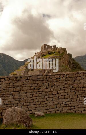 Machu Picchu Hügeloberhaus mit Steinmauer im Vordergrund Stockfoto