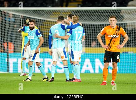 Graeme Shinnie (links), Max Bird und Louie Sibley von Derby County feiern, während Greg Docherty (rechts) von Hull City nach dem letzten Pfiff während des Sky Bet Championship-Spiels im MKM Stadium, Hull, niedergeschlagen aussieht. Bilddatum: Mittwoch, 18. August 2021. Stockfoto