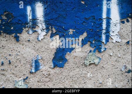 Abblätternde blaue Farbe, die die Textur einer alten Betonwand in Zagreb, Kroatien, enthüllt Stockfoto