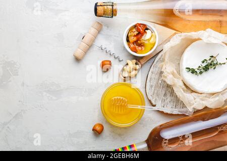 Rosenwein rosa Champagner Honig Brie Käse Nüsse Snacks Vorspeise auf hellgrauem Stein Hintergrund gesetzt. Mediterrane Speisen, Getränke zum Abendessen bei einer Weinparty. Stockfoto