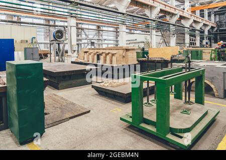 Im Inneren der riesigen Werkshalle mit Holzstapeln für die Herstellung von Formen. Holzarbeiten Herstellung Produktion Industrie. Stockfoto