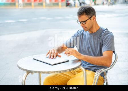 Junger latein, der seinen Computer draußen öffnete. Stockfoto
