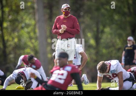 18. August 2021: Ron Rivera, Cheftrainer des Washingtoner Fußballteams, beobachtet, wie sich das Team während des Trainings im NFL-Trainingslager des Teams in den Washington Football Team Facilities in Ashburn, Virginia, aufwärmt. Fotograf: Cory Royster Stockfoto