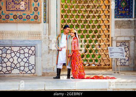 Samarkand, Usbekistan - 18. April 2021: Braut und Bräutigam in traditionellen usbekischen Kleidern in der antiken Stadt Registan, Samarkand in Usbekistan Stockfoto