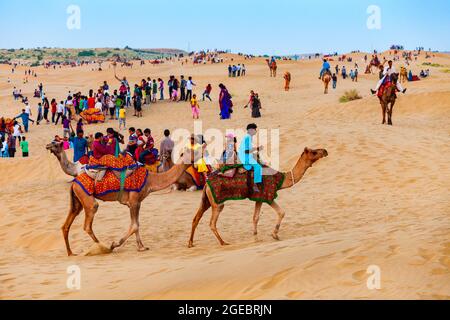 JAISALMER, INDIEN - 13. OKTOBER 2013: Unidentififizierte Menschen und Kamele auf Safari in der Thar Wüste nahe Jaisalmer Stadt in Indien Stockfoto