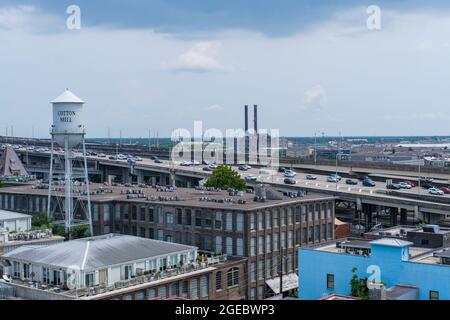 NEW ORLEANS, LA, USA - 30. JULI 2021: Blick von der Dachterrasse auf die Cotton Mill Apartments und den Verkehr auf dem Pontchartrain Expressway Stockfoto