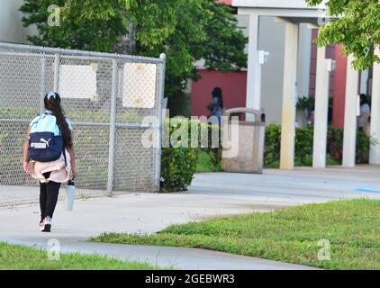 Pembroke Pines, USA. August 2021. PEMBROKE PINES, FLORIDA - 18. AUGUST: Schüler werden von ihren Eltern zur Schule abgesetzt, als sie von der Fakultät begrüßt werden, die sie am Mittwoch, den 18. August, zum ersten Unterrichts-Tag an der Broward County School in Pembroke Pines, Florida, USA, eintrifft. 2021. Das Florida State Board of Education sagte, dass es trotzige Schulbezirke zwingen würde, sich an den Executive Order des republikanischen Gouverneurs Ron DeSantis zu halten, der es ihnen verbietet, Studenten zu verbieten, Masken zu tragen, um einen Anstieg der Covid-19-Fälle zu verlangsamen. (Foto von JL/Sipa USA) Quelle: SIPA USA/Alamy Live News Stockfoto