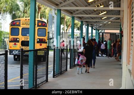 Pembroke Pines, USA. August 2021. PEMBROKE PINES, FLORIDA - 18. AUGUST: Schüler werden von ihren Eltern und Schulbussen zur Schule gebracht, als sie von der Fakultät begrüßt werden, als sie am Mittwoch, den 18. August, zum ersten Unterrichts-Tag an der Broward Public County School in Pembroke Pines, Florida, USA, ankommen. 2021. Das Florida State Board of Education sagte, dass es trotzige Schulbezirke zwingen würde, sich an den Executive Order des republikanischen Gouverneurs Ron DeSantis zu halten, der es ihnen verbietet, Studenten zu verbieten, Masken zu tragen, um einen Anstieg der Covid-19-Fälle zu verlangsamen. (Foto von JL/Sipa USA) Quelle: SIPA USA/Alamy Live News Stockfoto