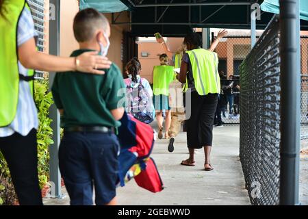 Pembroke Pines, USA. August 2021. PEMBROKE PINES, FLORIDA - 18. AUGUST: Fakultät begrüßt Studenten, die am ersten Unterrichtstag in der Pembroke Pines Charter Elementary A Broward County School in Pembroke Pines, Florida, USA, am Mittwoch, den 18. August, 2021. Das Florida State Board of Education sagte, dass es trotzige Schulbezirke zwingen würde, sich an den Executive Order des republikanischen Gouverneurs Ron DeSantis zu halten, der es ihnen verbietet, Studenten zu verbieten, Masken zu tragen, um einen Anstieg der Covid-19-Fälle zu verlangsamen. (Foto von JL/Sipa USA) Quelle: SIPA USA/Alamy Live News Stockfoto