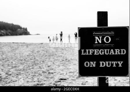 Schild an einem Sandstrand mit der Aufschrift „No Lifeguard on Duty“ Stockfoto