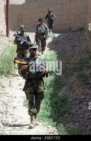 PATROUILLENBASIS FULOD, Provinz Helmand, Islamische Republik Afghanistan - Soldaten der afghanischen Nationalarmee vom 2. Tolay, 2. Kandak, patrouillieren einen Hügel in Sangin, Afghanistan, Mai 11. ANA-Soldaten führten die Anwesenheitssatrouille durch Sangin und waren für das Kommando und die Kontrolle der Patrouille verantwortlich. Stockfoto