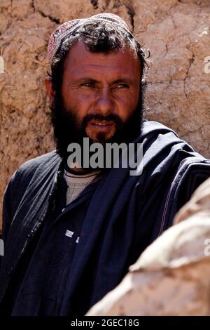 PATROUILLENBASIS FULOD, Provinz Helmand, Islamische Republik Afghanistan - Seaman Orlando C. Farase, ein Korpsmann für das Beratungsteam 4, das der Firma C, 1. Bataillon, 5. Marine-Regiment, angeschlossen ist, verbanden während einer Patrouille in Sangin, Afghanistan, Mai 11, die Hand eines Kindes. Soldaten der afghanischen Nationalarmee vom 2. Tolay, 2. Kandak, führten die Anwesenheitssatrouille durch Sangin und wurden von Marine-Beratern für das Team begleitet, die ausschließlich dort waren, um die ANA-Soldaten zu beobachten und Feedback zu geben. Farase, 22, stammt aus Pensacola, Florida Stockfoto