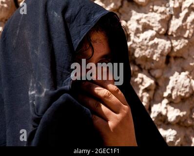 PATROUILLENBASIS FULOD, Provinz Helmand, Islamische Republik Afghanistan - Seaman Orlando C. Farase, ein Korpsmann für das Beratungsteam 4, das der Firma C, 1. Bataillon, 5. Marine-Regiment, angeschlossen ist, verbanden während einer Patrouille in Sangin, Afghanistan, Mai 11, die Hand eines Kindes. Soldaten der afghanischen Nationalarmee vom 2. Tolay, 2. Kandak, führten die Anwesenheitssatrouille durch Sangin und wurden von Marine-Beratern für das Team begleitet, die ausschließlich dort waren, um die ANA-Soldaten zu beobachten und Feedback zu geben. Farase, 22, stammt aus Pensacola, Florida Stockfoto