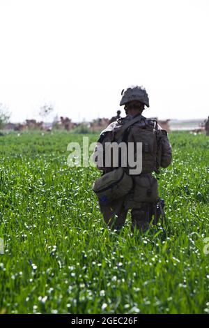 PATROUILLENBASIS FULOD, Provinz Helmand, Islamische Republik Afghanistan - Seaman Orlando C. Farase, ein Korpsmann für das Beratungsteam 4, das der Firma C, 1. Bataillon, 5. Marine-Regiment, angeschlossen ist, verbanden während einer Patrouille in Sangin, Afghanistan, Mai 11, die Hand eines Kindes. Soldaten der afghanischen Nationalarmee vom 2. Tolay, 2. Kandak, führten die Anwesenheitssatrouille durch Sangin und wurden von Marine-Beratern für das Team begleitet, die ausschließlich dort waren, um die ANA-Soldaten zu beobachten und Feedback zu geben. Farase, 22, stammt aus Pensacola, Florida Stockfoto