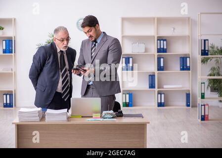 Zwei männliche Buchhalter im Budgetplanungskonzept am Arbeitsplatz Stockfoto