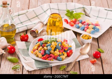 Farbige Gnocchi mit Gemüse und süßem Mais. Stockfoto