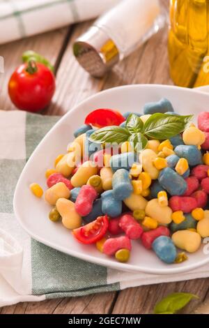Farbige Gnocchi mit Gemüse und süßem Mais. Stockfoto