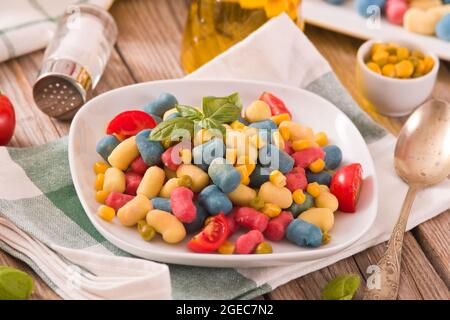 Farbige Gnocchi mit Gemüse und süßem Mais. Stockfoto