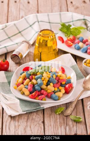 Farbige Gnocchi mit Gemüse und süßem Mais. Stockfoto