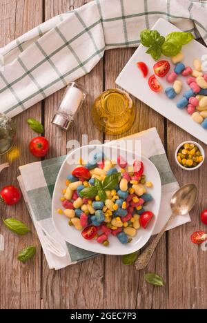 Farbige Gnocchi mit Gemüse und süßem Mais. Stockfoto