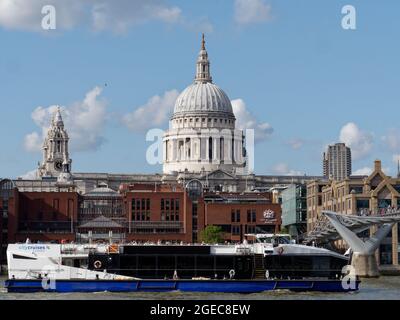 Das Thames-Flussboot fährt vor der St Pauls Cathedral und der City of London School mit der Millennium Bridge rechts vorbei. Stockfoto