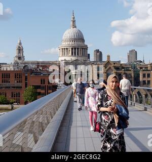 London, Greater London, England, August 10 2021: Menschen verschiedener Ethnien gehen auf der Millennium Bridge mit der St. Pauls Cathedral hinter sich. Stockfoto