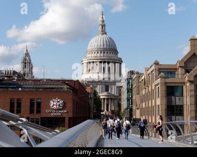 London, Greater London, England, August 10 2021: Menschen gehen auf der Millennium Bridge mit der St. Pauls Cathedral hinter sich. City of London School links. Stockfoto