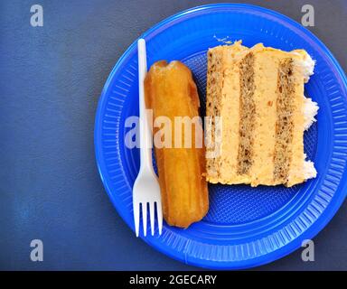 Kuchen und türkissüßes Tulumba Dessert in einem blauen Einwegteller Draufsicht.Eastern ein westliches Kulllurkonzept Stockfoto