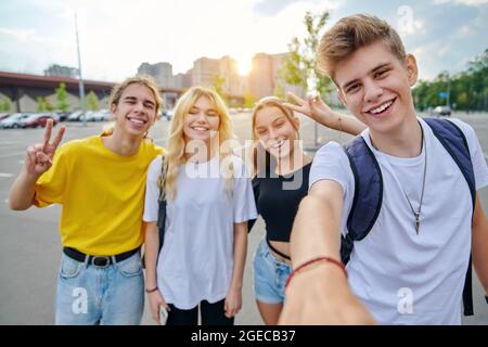 Lächelnde Gruppe von Teenagern, die Selfie machen, glückliche vier Teenager, die die Kamera betrachten Stockfoto