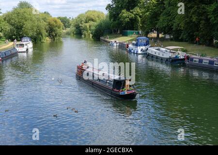 Ein Schmalboot (Kanalboot) fährt in Richtung Wallingford Bridge an der Themse in Wallingford, Großbritannien. Stockfoto