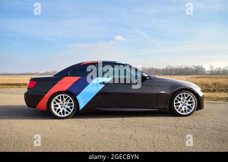 Berlin - April 2014: BMW 3 series E93 328i Cabriolet mit m-Pack Logo Streifen im Freien. Rechte Seitenansicht. BMW Cabriolet der 3-er Serie im Feldland Stockfoto