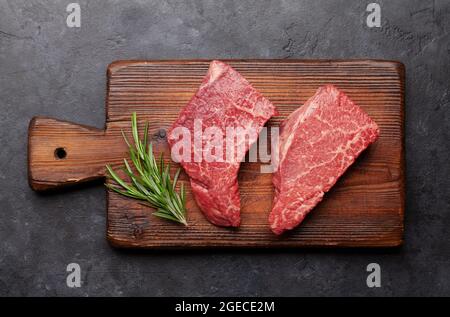 Marmoriertes Rindersteak. Zwei frische rohe Filetsteaks auf Schneidebrett. Draufsicht flach liegend Stockfoto