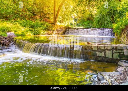 Kleiner doppelter Wasserfall am Waldbach. Gaden Steinschleuder in ruhiger Waldstimmung. Stockfoto