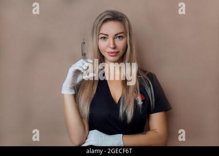 Kosmetologie und Spa-Verfahren. Arzt Kosmetologe in Handschuhen und mit einer Spritze in den Händen steht eine schwarze Robe Nahaufnahme Stockfoto